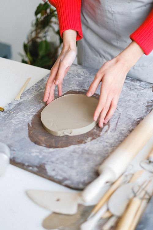 Clay, tools and a wooden board laid out from above for a clay project