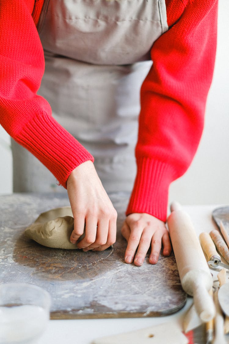 Crop Woman Kneading Clay At Table