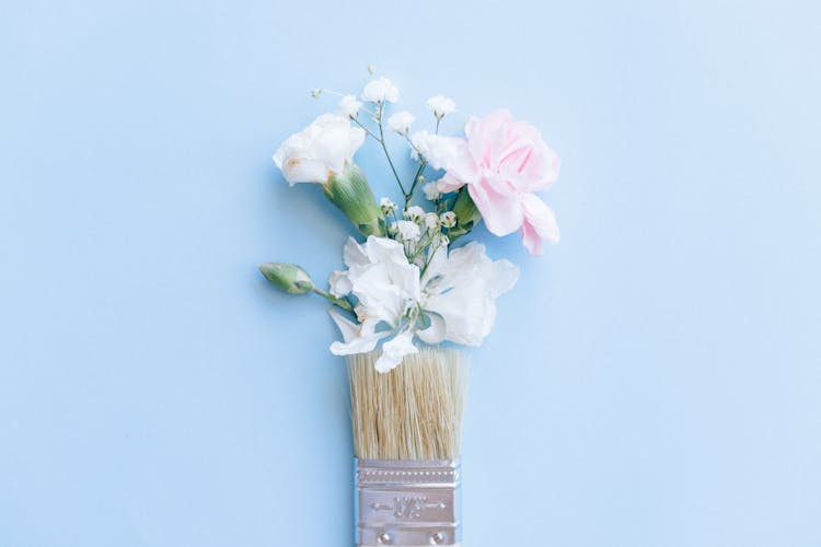 Blooming Flowers And Paintbrush On Light Blue Background