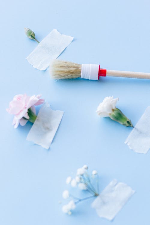 Free Close-Up Shot of a Paint Brush near Taped Flowers Stock Photo