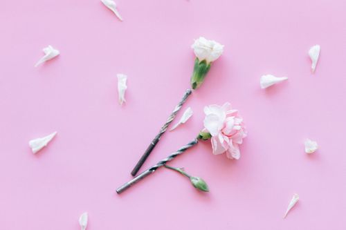 Free Soft pink flowers and drill bits create an artistic contrast on a pastel pink background. Stock Photo