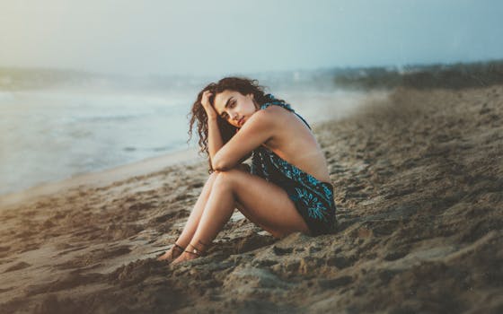 A woman enjoying a serene moment on the sandy shores of Oaxaca, Mexico, with the sea in the background.