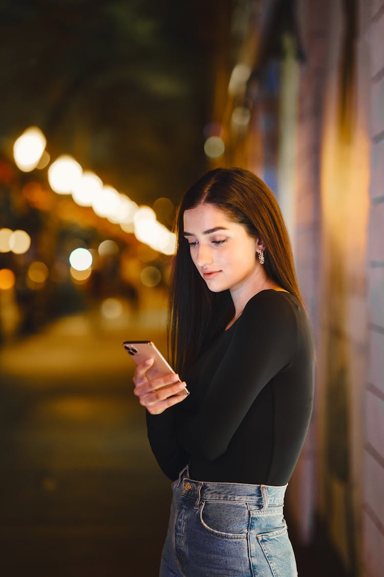 Pretty Woman In Black Long Sleeve Shirt Using A Cellphone