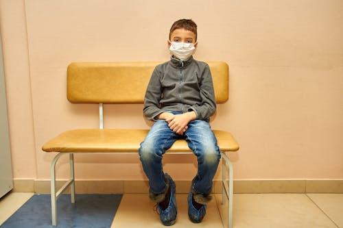 Free A Boy Wearing Face Mask Sitting on the Chair Stock Photo