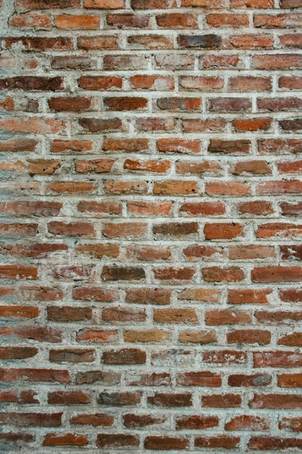 Close-up view of a rustic red brick wall showcasing natural texture and pattern.