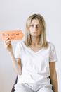 Blonde Woman Holding an Orange Paper with a Message
