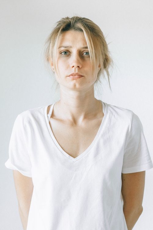 Free Close-up portrait of a woman in a white shirt looking directly at the camera. Stock Photo
