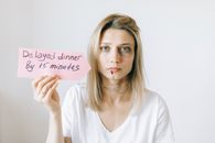 Woman in White Shirt Holding a Pink Paper with Message