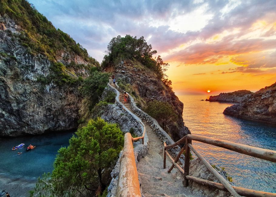 Breathtaking sunset over rocky cliffs and sea in San Nicola Arcella, Italy.