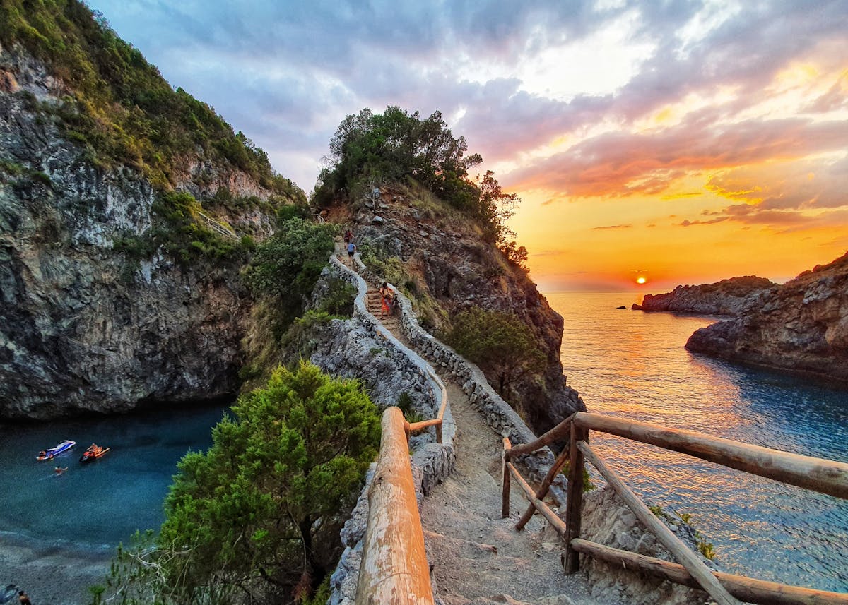 Scogliera a picco sul mare turchese con spiaggette rocciose visibili