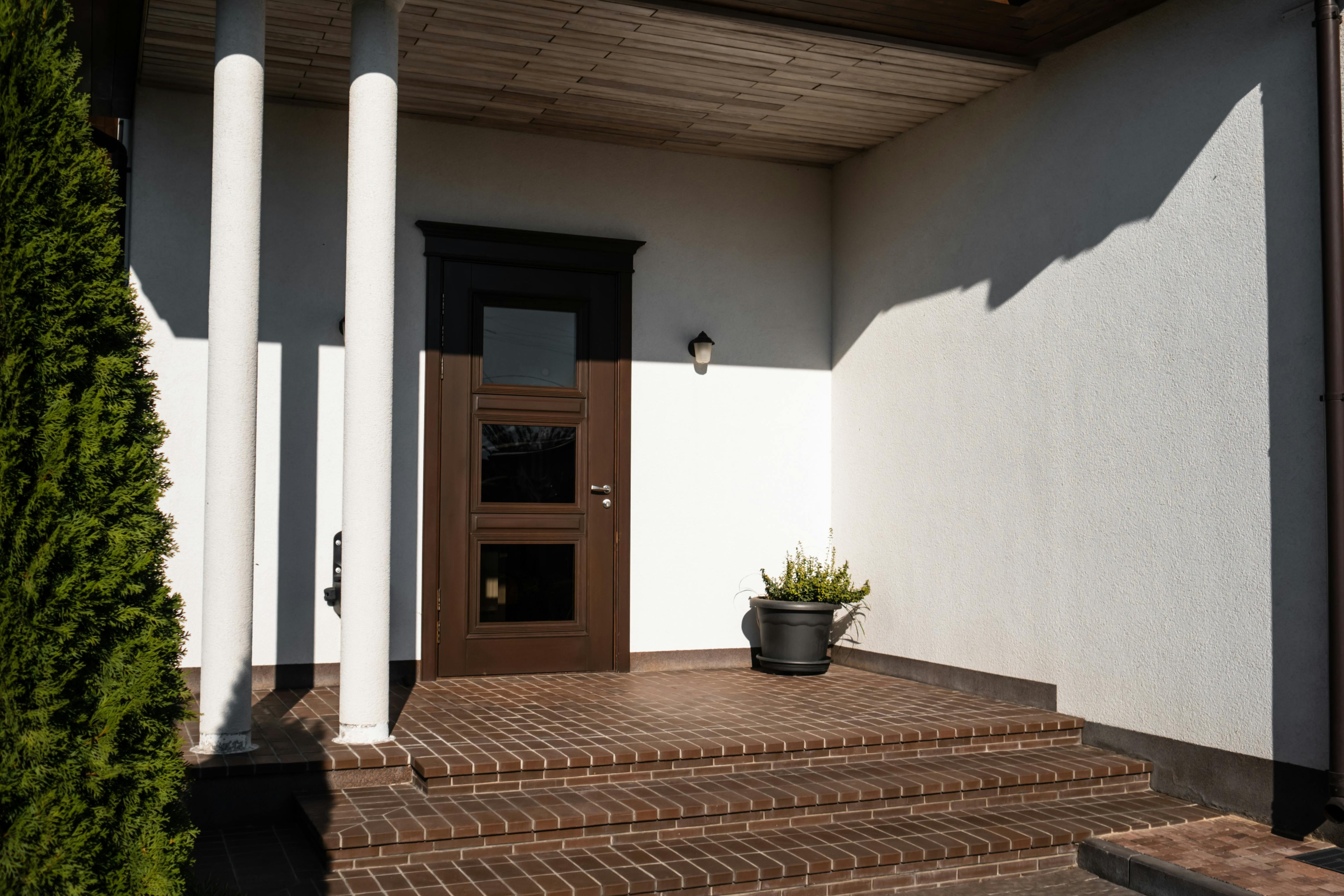 brown wooden door on white concrete wall