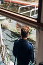 Faceless man standing on boat in sea