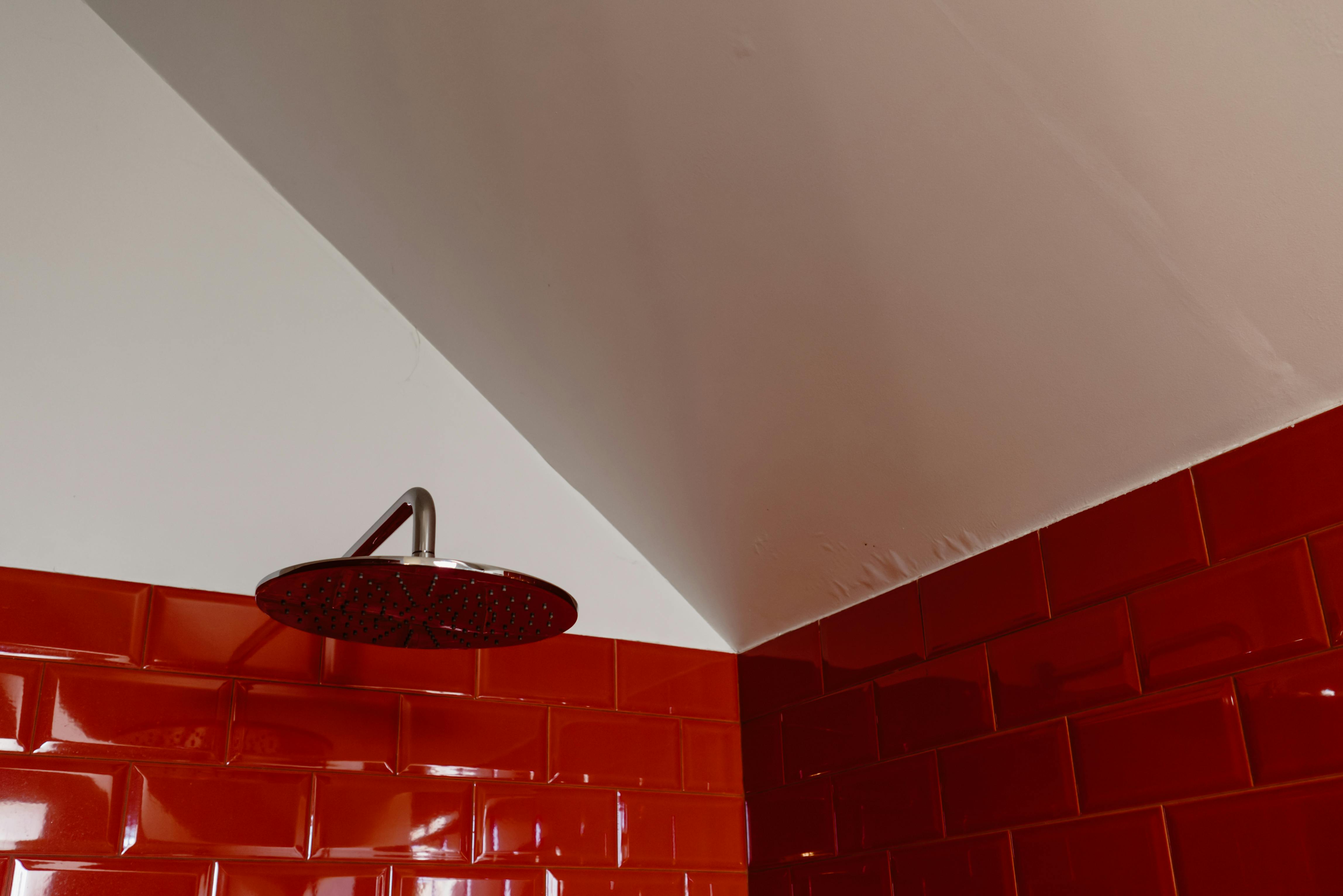 a round shower head on the red brick wall