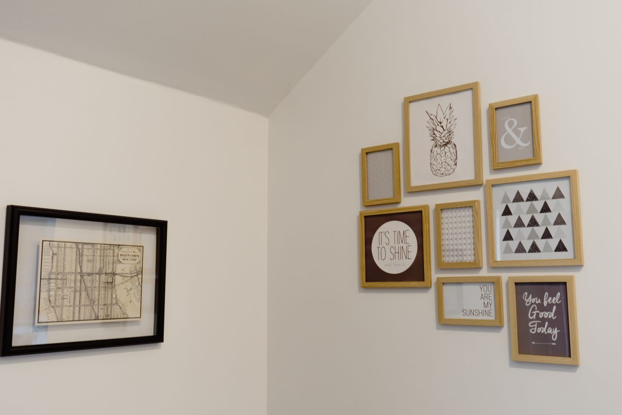 Wooden picture frames arranged with even spacing on a white wall