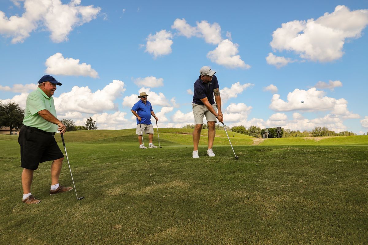 Three men playing golf together