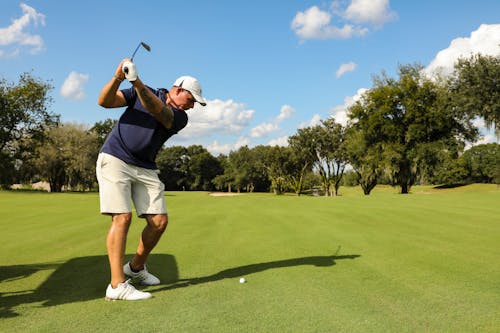 Free Man in Blue Top and White Cap Playing Golf Stock Photo