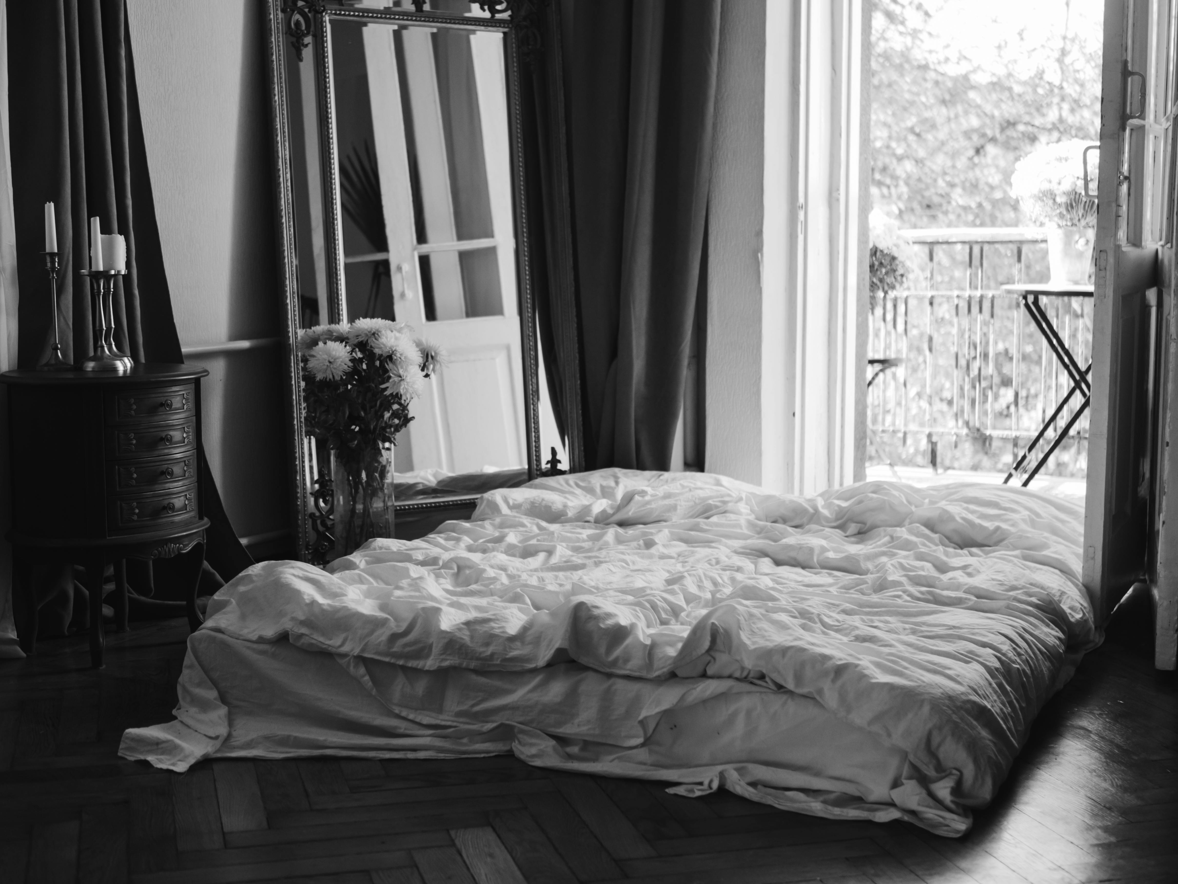 grayscale photo of bed with bed linen