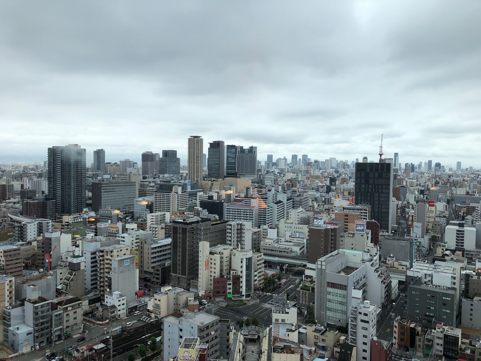 Discover the expansive cityscape of Japan featuring high-rise buildings under a cloudy sky.