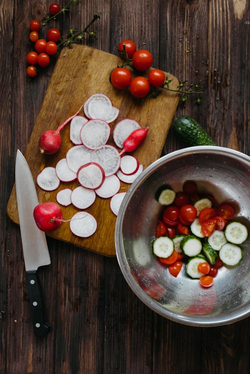 Sliced Radish on Wooden Chopping Board Beside Sliced Vegetables Stainless Steel Bowl