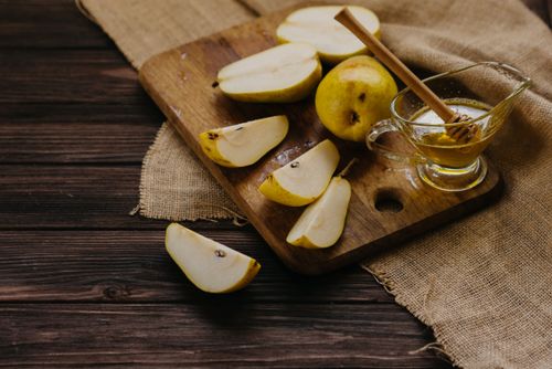 Free Freshly sliced pears with honey on a rustic wooden board, perfect for healthy snacking. Stock Photo