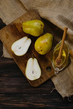 Fresh pears and honey on a wooden board, perfect for a healthy meal.