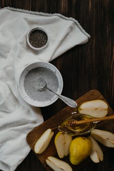 A delicious homemade chia pudding with fresh pears and honey, set on a rustic wooden table.