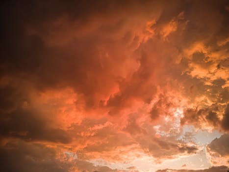 Dramatic orange clouds during a summer sunset, showcasing nature's beauty and vibrant details.