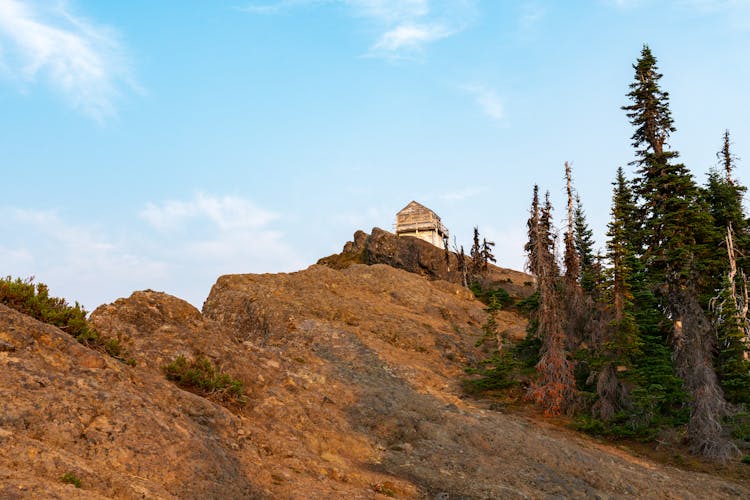 House On Top Of Brown Rocky Mountain 