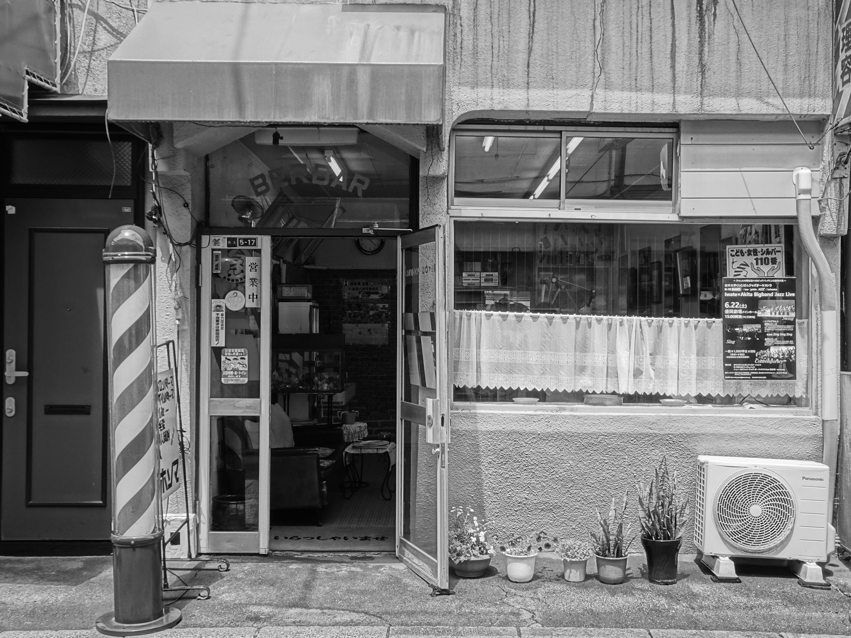 街の商店街を歩きながら店舗の外観を眺めている様子。人通りと店構えが同時に映っている写真