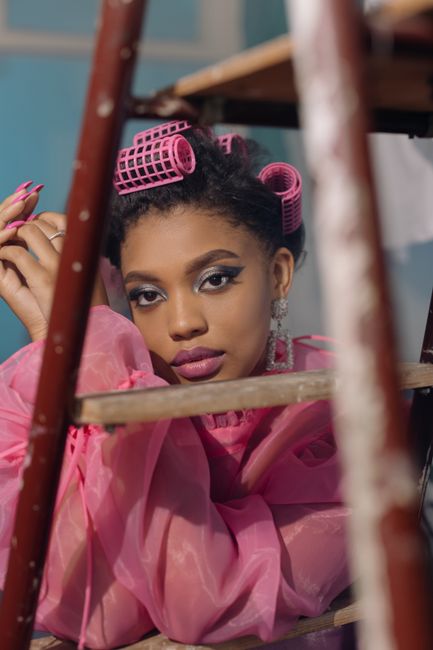 Close-up portrait of a fashionable woman with hair curlers, indoors.