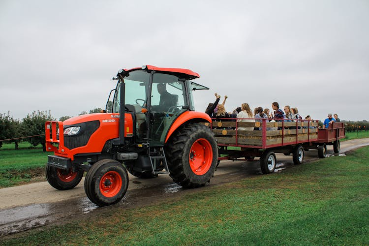 Tractor With People Visiting Farmland In Cart