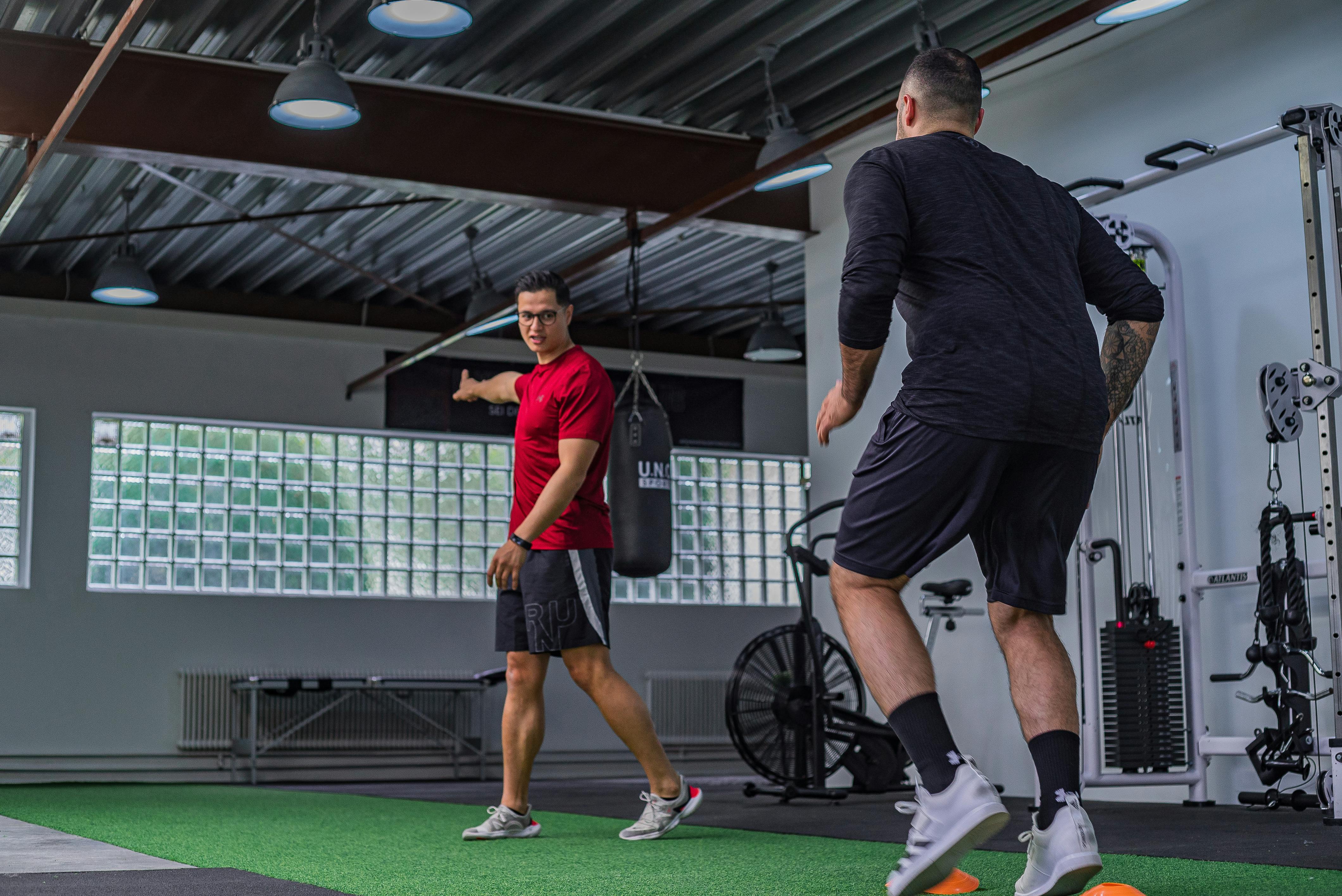 strong man training with instructor in gym