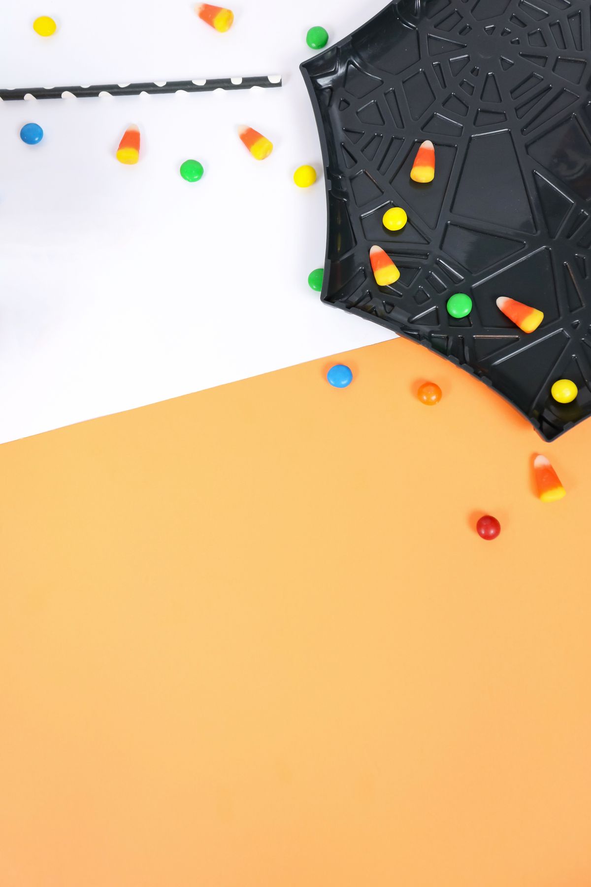 Colorful candies scattered on a black spider web plate