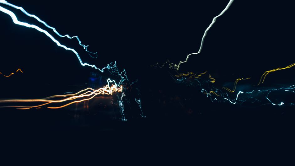 Dynamic abstract image showcasing vividly colored light streaks against a black background.