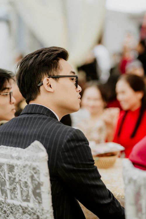 Free Side view of an Asian man in glasses attending a formal indoor event. Elegant ambiance. Stock Photo