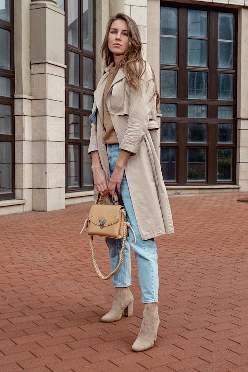 Trendy woman standing on paved sidewalk