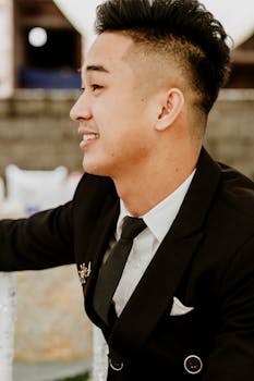 Portrait of a young man in a suit smiling, dressed for a formal event.