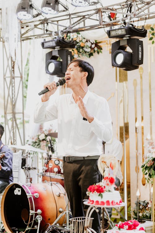 Man in White Long Sleeve Shirt Singing