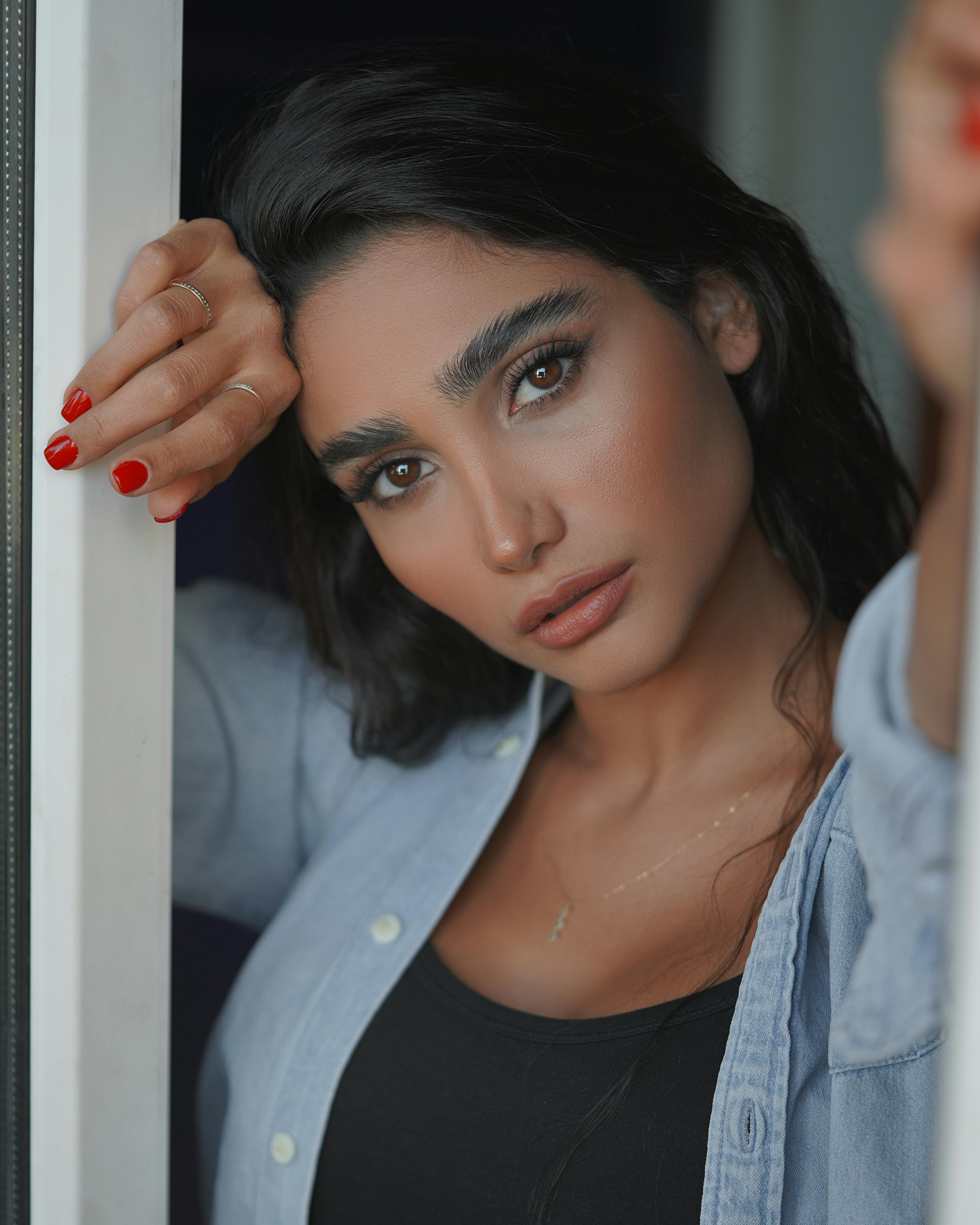 Elegant close-up portrait of a woman with striking features and red nails. Perfect for beauty and lifestyle themes.