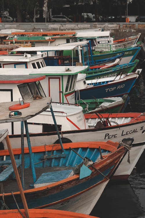 Colourful old small fishing boats moored on river pier in city in daytime