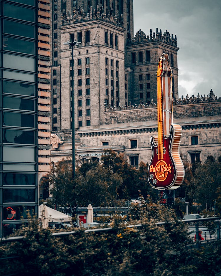 Giant Guitar Logo Of Hard Rock Cafe In Warsaw, Poland With The Palace Of Culture And Science In The Background 