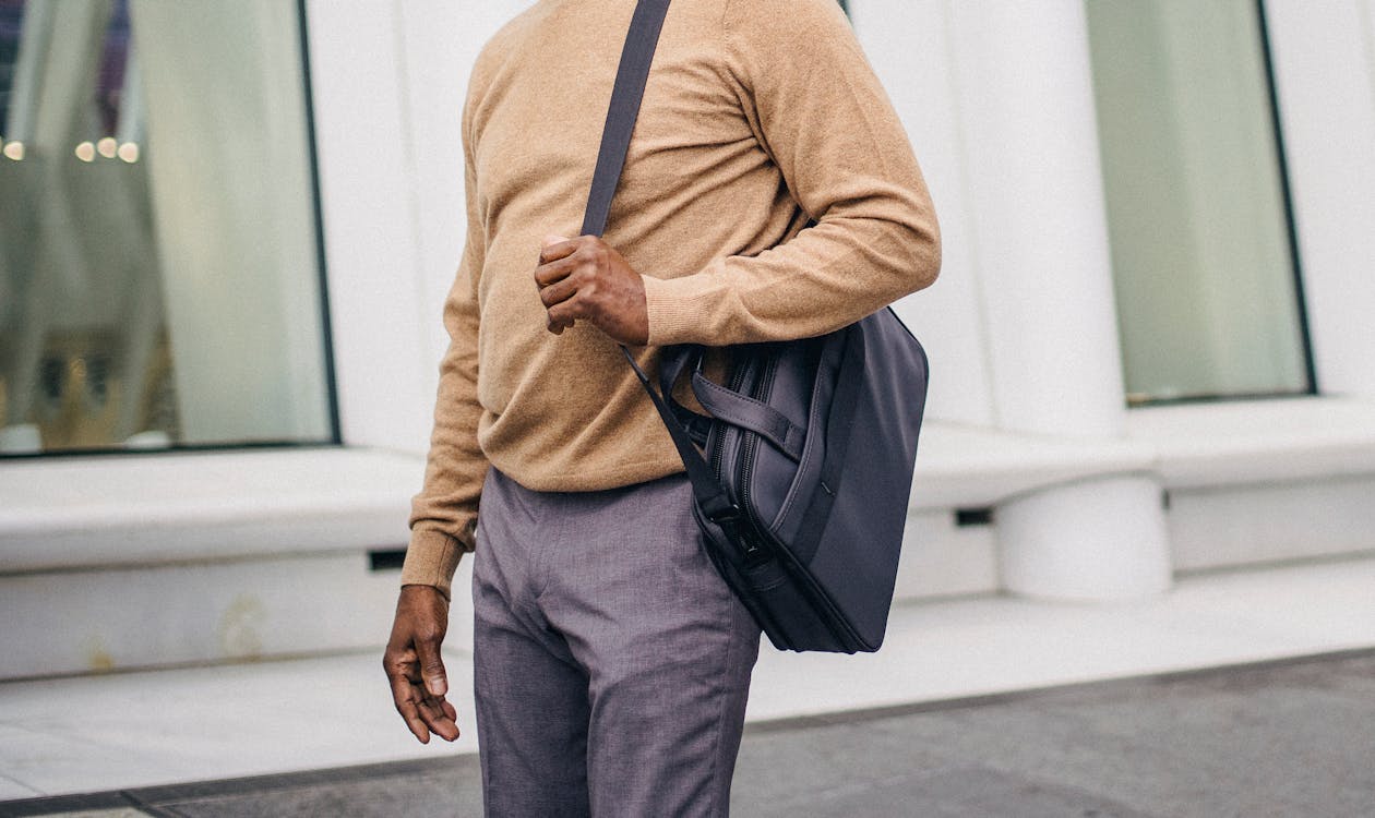 Crop black man with bag standing on street · Free Stock Photo