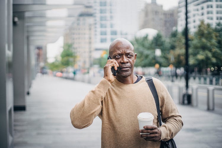 Serious Black Male Having Phone Call On Street