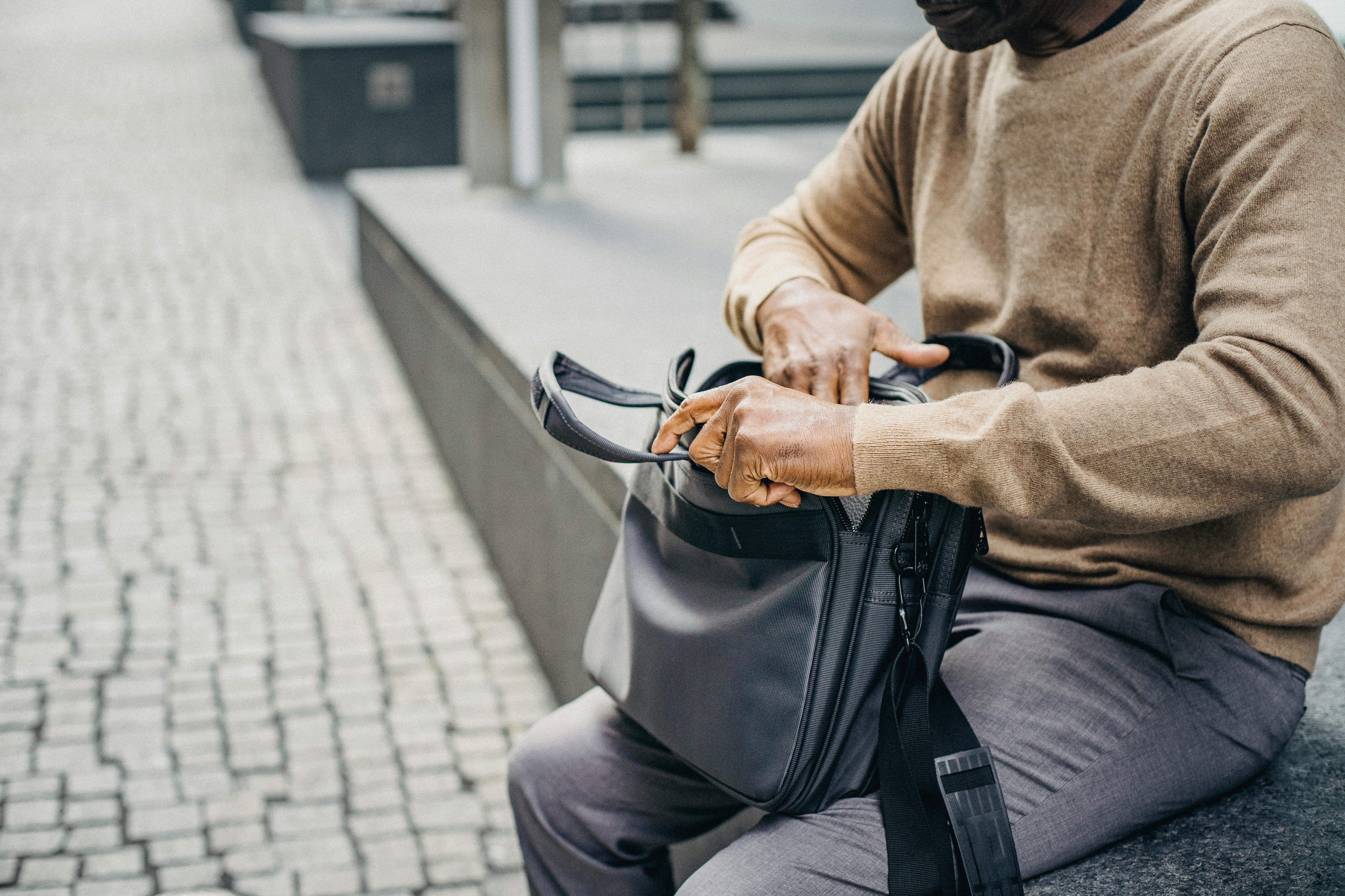 crop black man with case bag on street