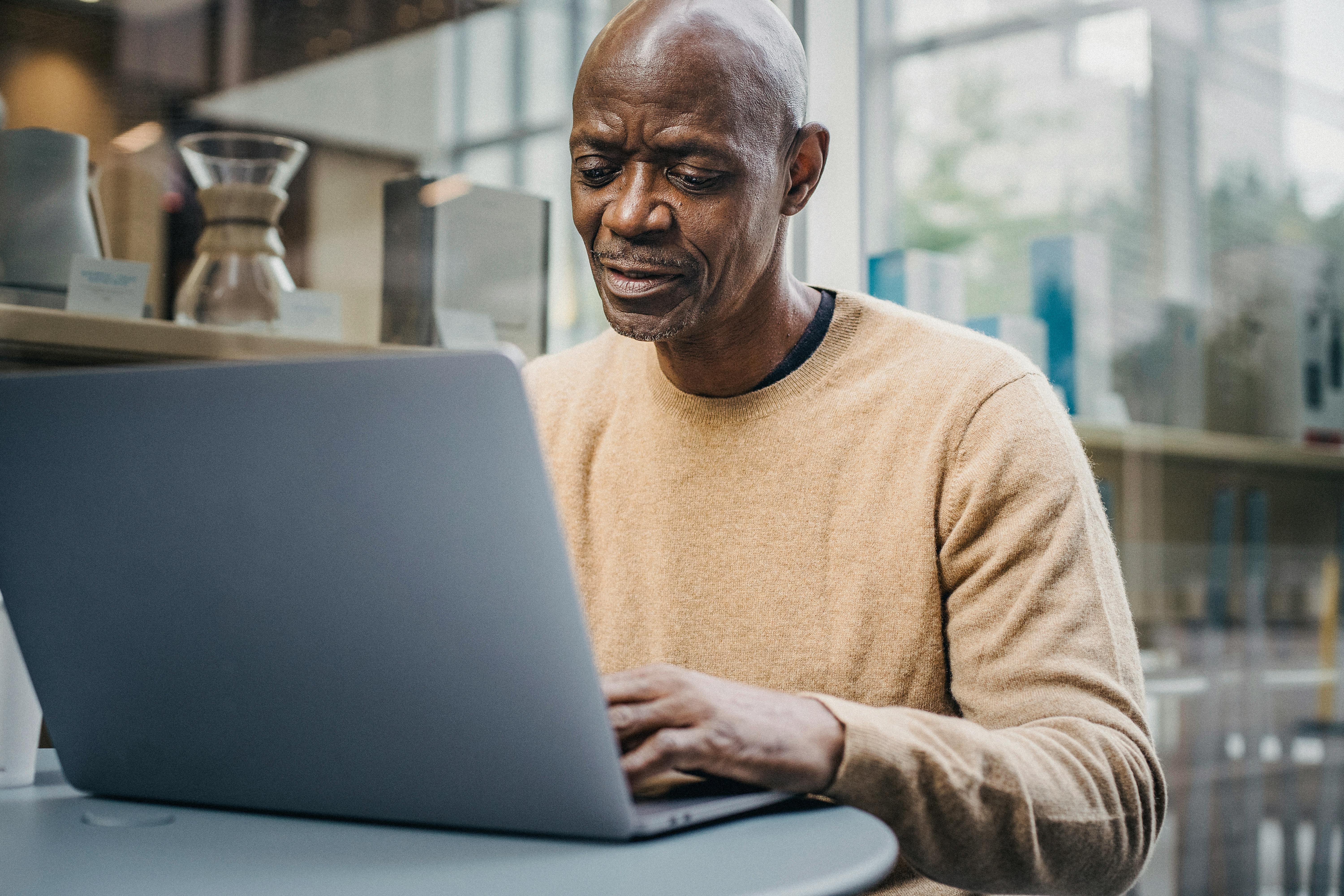 mature black businessman working on laptop in street