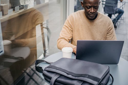 Confiado Empresario Negro Con Laptop En Street Cafe