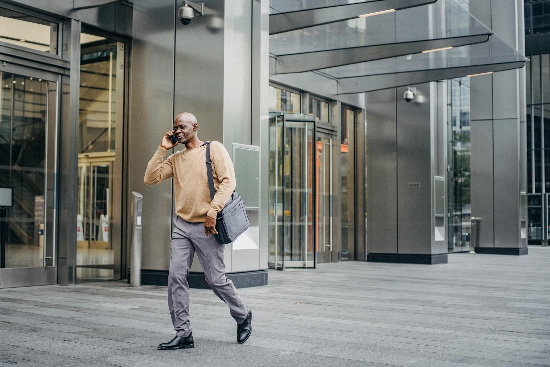 Elegant black entrepreneur walking and talking on phone