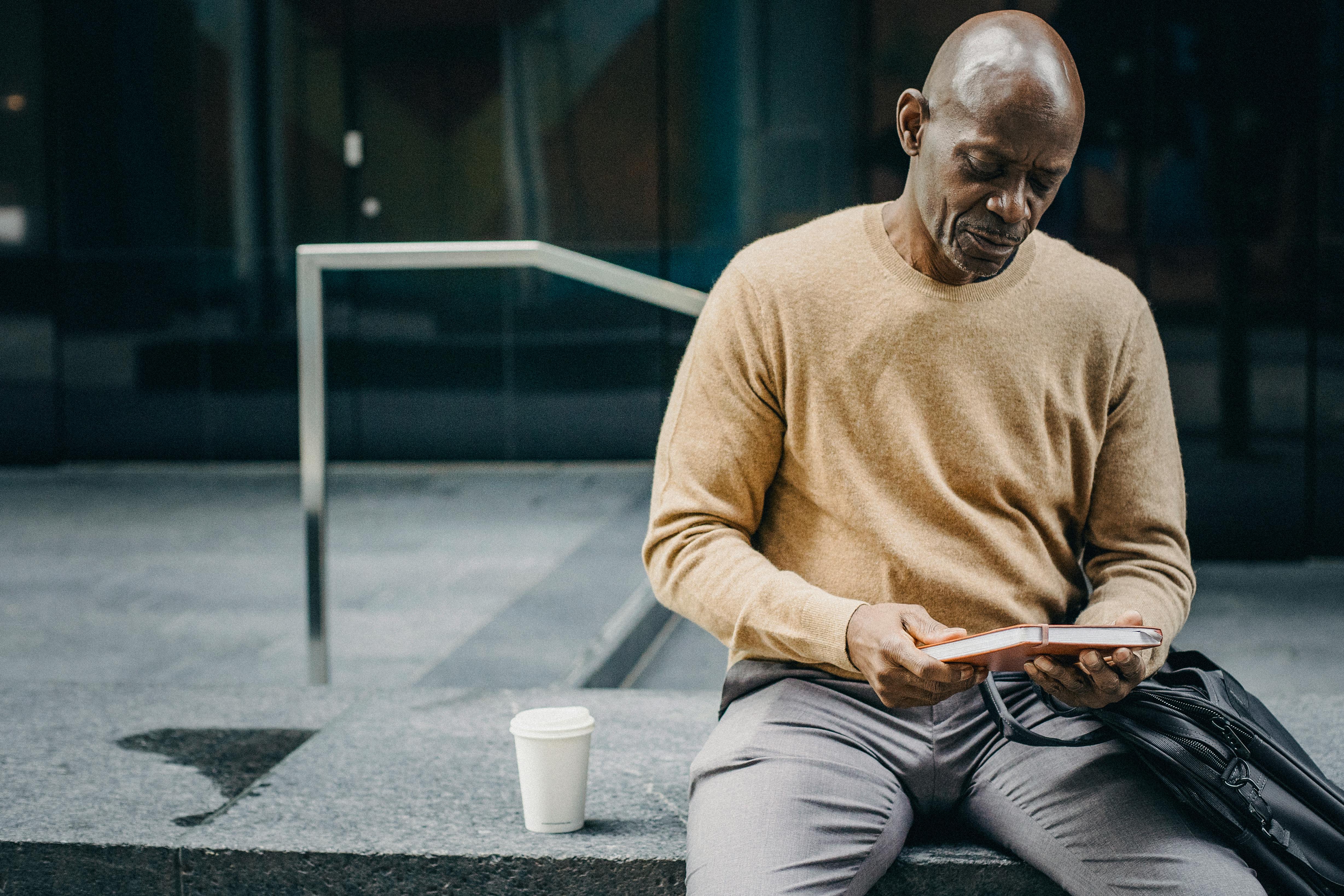 calm businessman with coffee and planner in street