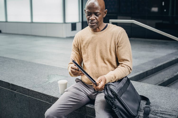 Mature Black Businessman With Folder In Street