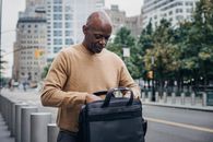 Focused black businessman opening case bag